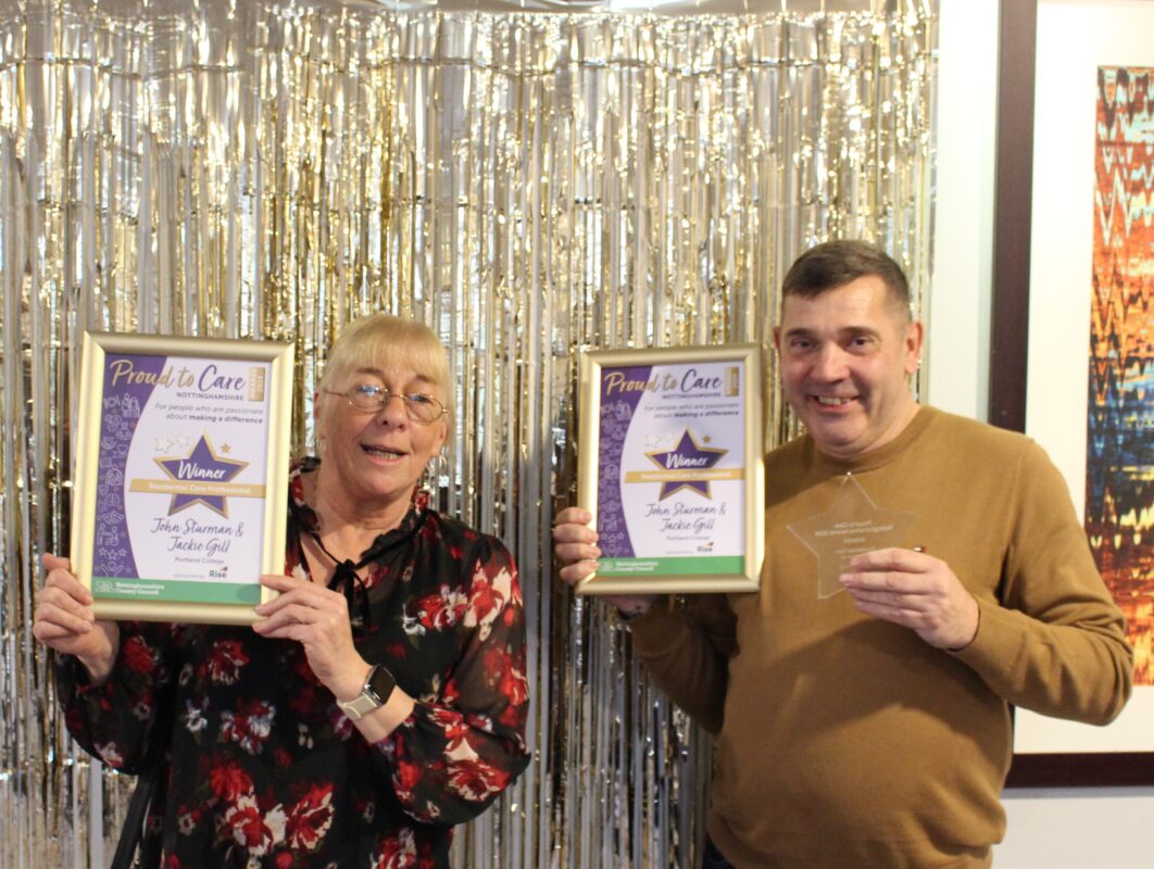 On the left, Jackie, and the right, John, both holding their framed Winners certificates.